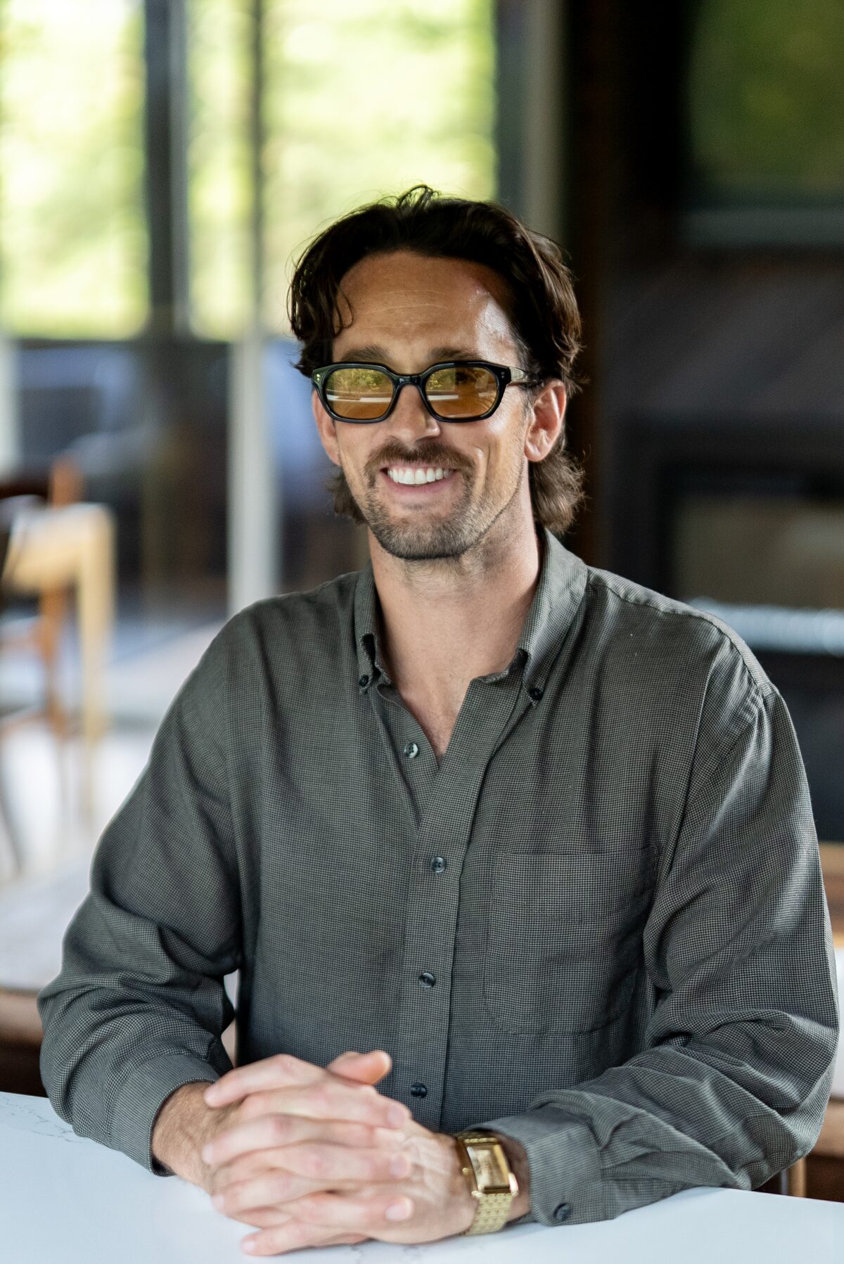 Evan J. Montgomery at a table, hands folded, smiling
